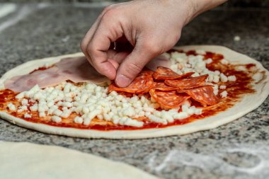 Hands preparing a pizza. The process of making pizza. Closeup hand of chef baker making pizza at kitchen.