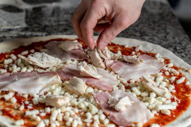 Cook hands preparing original Italian raw pizza, preparation in traditional style. The process of making pizza.