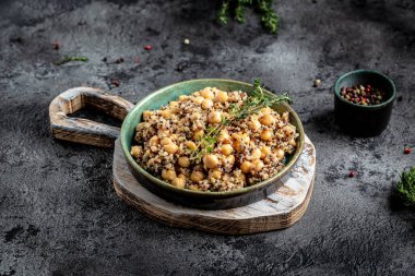 Buda yayı, kinoa salatası, nohut ve kekik. Koyu arkaplanda süper yemek, üst görünüm.