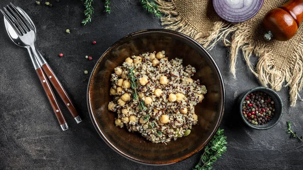 Buda yayı, kinoa salatası, nohut ve kekik. Koyu arkaplanda süper yemek, üst görünüm.