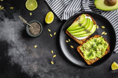 Tahıl ekmeğine krem peynirli avokado tostu. Vejetaryen gıda konsepti. Temiz yemek. Üst görünüm.