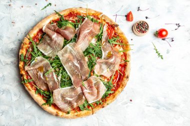 Jambonlu jambonlu dilimlenmiş pizza, roka ve parmesan peyniri. İtalyan mutfağı. en üstteki görünüm.