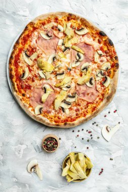 Enginarlı pizza, şampiyonlar, arka planda jambon ve mozzarella, üst manzara. Geleneksel İtalyan pizzası.