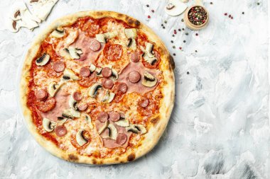 Lezzetli Capriciosa pizzası. Hafif arka planda jambonlu ve mantarlı klasik pizza. İtalyan pizzası odun ateşinde pişirilir..