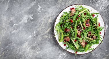 Tavuk ciğeri, kivi, nar ve roka ile salata. Üst görünüm.