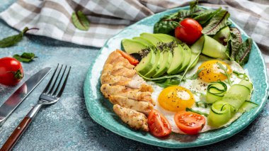 Sağlıklı kahvaltı. Tavuk ızgara fileto salata taze domates, salatalık, yumurta ve avokado. Keto Paleo diyet menüsü. en üstteki görünüm.