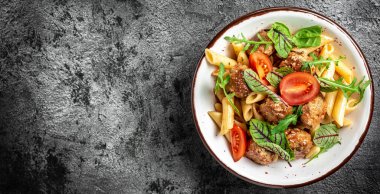 Domates soslu köfteli makarna ve kasede sebze. İtalyan makarnası. Uzun pankart biçimi, üst görünüm.