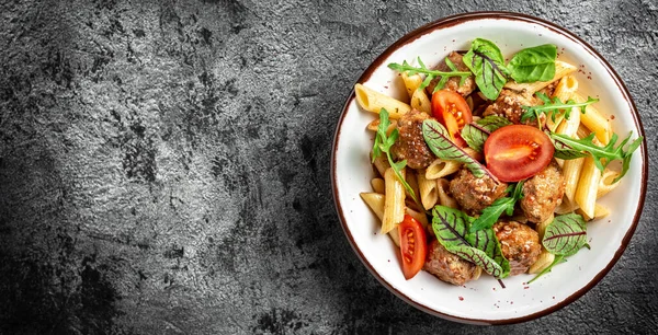 Domates soslu köfteli makarna ve kasede sebze. İtalyan makarnası. Uzun pankart biçimi, üst görünüm.