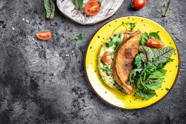 Yumurta, peynir ve ıspanak salatasından yapılmış Frittata. Frittata, gri arka planda sarı tabakta İtalyan omleti. Ketogenik, keto yemeği. afiş, metin için menü tarifi yeri, üst görünüm