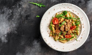 Köfte ve domates soslu makarna. İtalyan makarnası. gri arka plan. afiş, metin için menü tarifi yeri, üst görünüm.