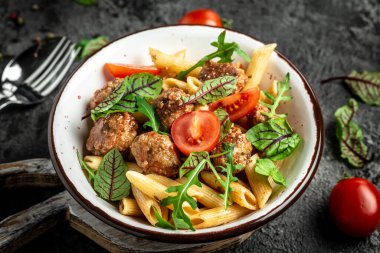 Köfteli makarna ve koyu arkaplanda domates sosu. afiş, menü tarifi, üst görünüm.