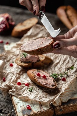 Kadın ellerini kapat ve Belçika usulü ördek ciğeri ekmeği hazırlayıp ye. Taze ev yapımı tavuk ciğeri ezmesi kızarmış ekmek, yeşillik ve nar. metin için yer.