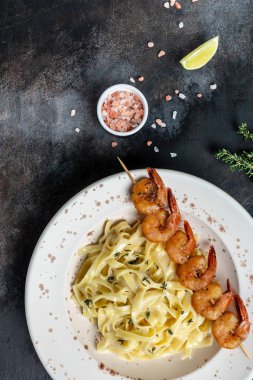 Makarna deniz ürünleri. Karides ve krema soslu tagliatelle makarnası. İtalyan usulü makarna. Üst Manzara. dikey resim, metin için yer.