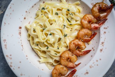 Izgara karides, beşamel sosu ve kekik ve fettucine makarna ile birlikte deniz ürünleri tagliatelle makarna kapatın. İtalyan yemeği. Sağlıklı diyet deniz ürünleri konsepti. Üst görünüm.
