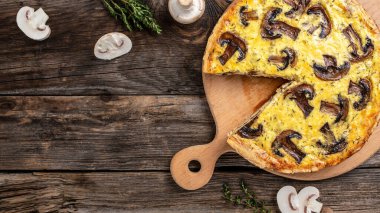 Mantarlı turta, tavuk ve otlu. Geleneksel Fransız turtası Quiche Lorraine ahşap masada. afiş, metin için menü tarifi yeri, üst görünüm.