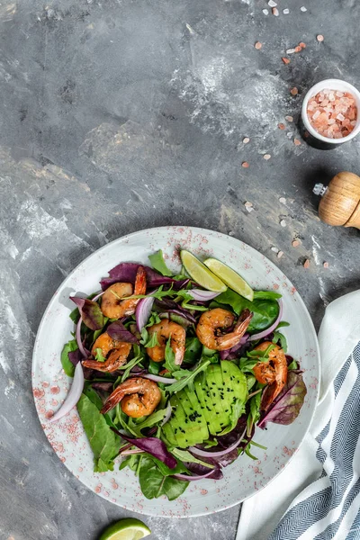 Seafood salad with avocado and shrimps. Tasty veg mixed leaves, grilled prawn shrimps. Healthy food. vertical image, place for text.