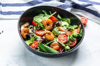 Füme karidesli deniz ürünleri salatası, kiraz domatesleri, salatalık ve karışık yapraklar. afiş, metin için menü tarifi yeri, üst görünüm.