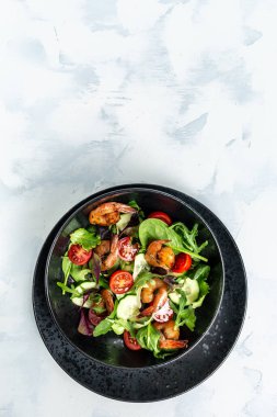 Füme karidesli deniz ürünleri salatası, kiraz domatesleri, salatalık ve karışık yapraklar. Sağlıklı yiyecekler. dikey resim, metin için yer.