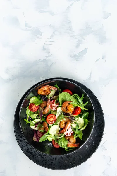 Füme karidesli deniz ürünleri salatası, kiraz domatesleri, salatalık ve karışık yapraklar. Sağlıklı yiyecekler. dikey resim, metin için yer.