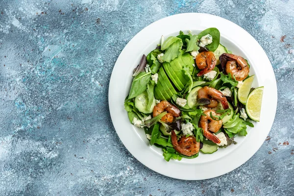 Diet menu. Healthy salad with avocado, blue cheese and smoked shrimps. Vegan food. Flat lay. Top view.