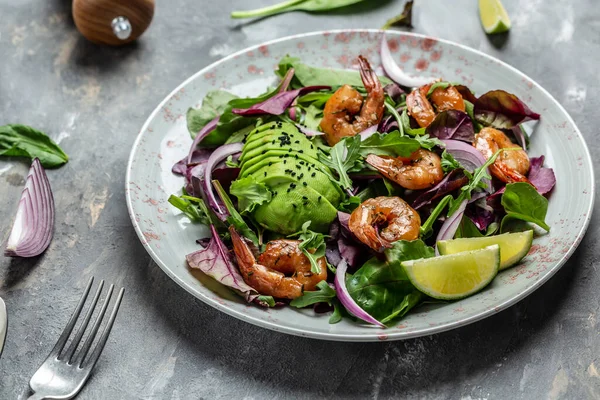 Healthy vegetarian salad with avocado and shrimps salad. Seafood concept. Tasty veg mixed leaves, grilled prawn shrimps, top view.