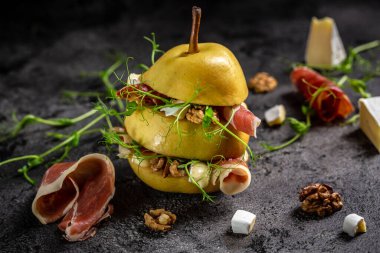 İtalyan antipasti atıştırmalıkları. Prosciutto, İspanyol jamonu, armut, camembert, ceviz ve mikroyeşil ile armut iştah açıcı. Yemek tarifi geçmişi.