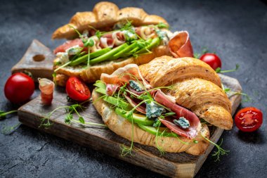 Prosciutto, amon, blue, cheese avocado, microgin ve cherry domatesli kruvasan. Akdeniz aperatifi. Kahvaltı konsepti.