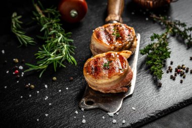 Biftek kaplı sığır filetosu koyu beton arka planda eski kasap eti üzerine pastırma. afiş, metin için menü tarifi yeri, üst görünüm.