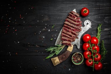 Sulu sığır etli biftek az pişmiş. Eski kasapta servis ediliyor. Koyu tahta arka planda. afiş, metin için menü tarifi yeri, üst görünüm.