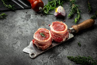 Pastırmaya sarılı sığır filetosu. Koyu beton arka plandaki eski et kasaplarına yapıştırılmış. en üstteki görünüm.