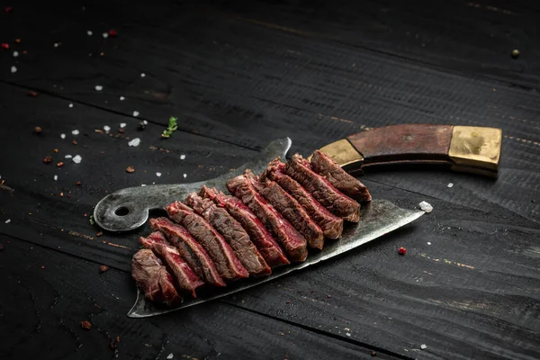 Barbecue Rib Eye Steak rump steak Dry Aged Wagyu on old meat cleaver on dark wooden background. banner, menu recipe place for text, top view.