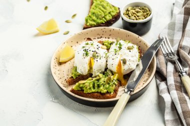 Avokado ve haşlanmış yumurtalı sağlıklı sandviç. Nefis bir kahvaltı ya da hafif bir arka planda atıştırmalık..