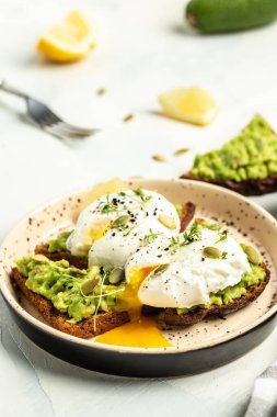 Sağlıklı kahvaltı, tam buğday ekmeği, avokado ve haşlanmış yumurta. Vejetaryen yemeklerle kahvaltı, sağlıklı beslenme konsepti..