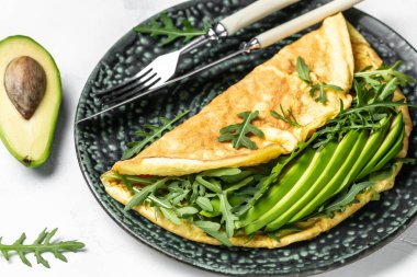 Yeşil sebzeli omlet avokado ve roka lezzetli vegan, vejetaryen kahvaltısı, yemek tarifi geçmişi. Kapat.,