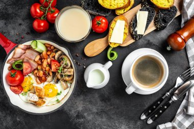 Kızarmış yumurta, fasulye, domates, mantar, pastırma ve tost.,