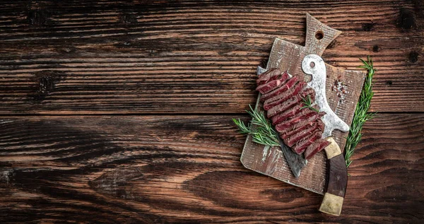 grilled steak over meat butcher knife. Food recipe background. Close up. Long banner format.