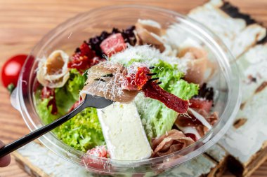 Prosciutto salatası, jambon ve greyfurt jamonu, salata karışımı, greyfurt, vişneli domates, parmesan peyniri. Paket paket veya yiyecek teslimatı için. metin için yer, üst görünüm.