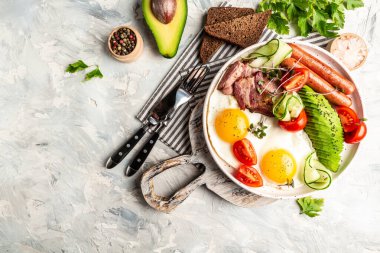 Sağlıklı besleyici paleo keto kahvaltı diyeti kızarmış yumurta, pastırma, avokado, peynir ve taze salata. Keto kahvaltısı ya da öğle yemeği. Pankart, yemek servisi menü tarifi yeri, metin, üst görünüm.