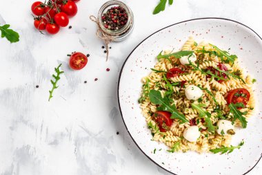 Domatesli Caprese salatalı makarna, arka planda mozzarella sebze ezmesi, vejetaryen salatası, afiş, yazı için menü tarifi yeri, üst görünüm..