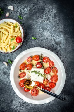 Fırında makarna. Feta, kiraz domatesli makarna, beyaz peynir, sarımsak ve bitkilerle ünlü. Uzun pankart biçimi, üst görünüm.