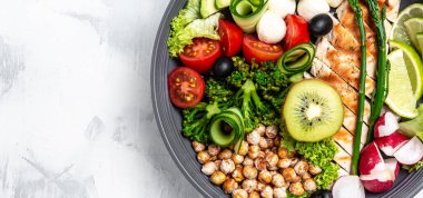 Lahana salatası, avokado, kuşkonmaz, nohut, brokoli, turp, tavuk, salatalık, zeytin ve mozzarella ile Buda kasesi. Uzun pankart biçimi, üst görünüm.