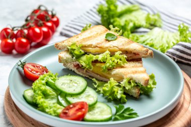 Jambonlu, peynirli ve salatalı sıcak sandviç. Bastırılmış ve kızartılmış çifte aperatif.,