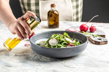 Evde salata hazırlayan bir kadın, turplu bahar salatası ve yeşil soğan, diyet menüsü. Vejetaryen yemeği,