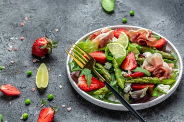 Taze yeşil kuşkonmaz, çilek, roket ve süzme peynirli vejetaryen sebze salatası. Diyet pankartı, metin için menü tarifi yeri, üst görünüm.