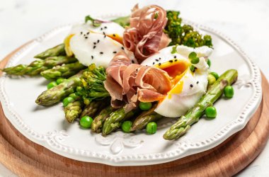 Lezzetli kuşkonmaz, haşlanmış yumurta, jambon, jambon, prosciutto. Sağlıklı yiyecekler. Diyet öğle yemeği konsepti. Keto Paleo diyet menüsü.