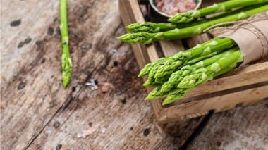 Ahşap bir kutuda taze yeşil kuşkonmaz, afiş, metin için menü tarifi yeri, üst görünüm,