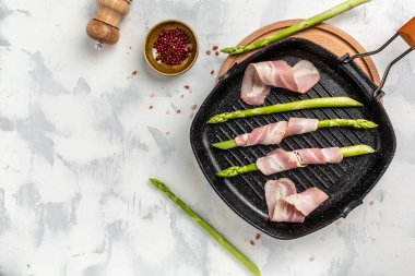 Izgara tavaya pastırma sarılmış yeşil kuşkonmaz. afiş, metin için menü tarifi yeri, üst görünüm.