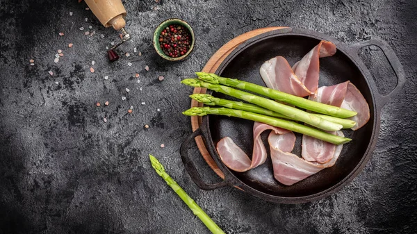 Kuşkonmaz ve pastırma pişirmeye hazır. Kuşkonmaz ve pastırma. Parma jambonuna sarılmış kuşkonmaz..