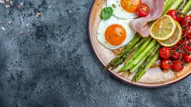 Yeşil kuşkonmaz, pastırma, jambon ve vişneli domatesli yumurta. Sağlıklı kahvaltı, ketogenik diyet. Sağlıklı yemekler, diyet menüsü. afiş, metin için menü tarifi yeri, üst görünüm.