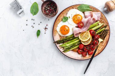 Kahvaltıda yumurta, kuşkonmaz, jambon, domates ve salata. Sağlıklı dengeli yiyecekler. Üst görünüm pankartı.